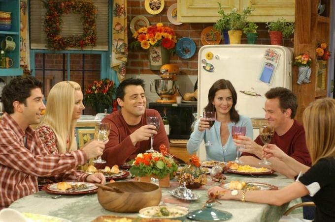 ross, phoebe, joey, monica, chandler og rachel fra tv-show-venner samlet omkring bordet og hejste glassene i en skål