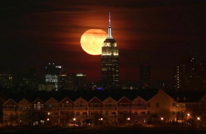 Fuldmånen stiger op bag Empire State Building i New York City
