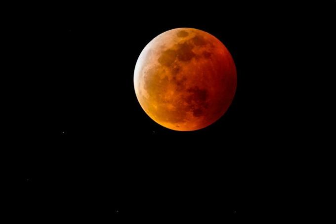 en blodmåne eller fuldmåne med en rødlig skygge på grund af en total måneformørkelse på nattehimlen