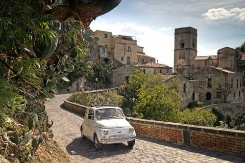 Hvid bil kører gennem Toscana - landsbyveje
