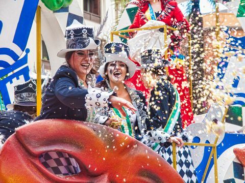 algeciras muntre grinende karnevalsdeltagere kaster konfetti under karnevalets parade på gaden i algeciras, cadiz, andalusien