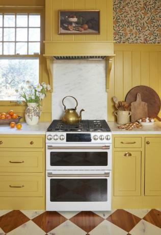 gult stuekøkken med hvid gaskomfur