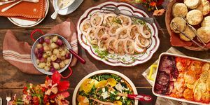 et bord dækket med tallerkener med mad inklusive kalkunroulade, vintersalat, kiks, rodfrugtsgratin og søde og sure løg