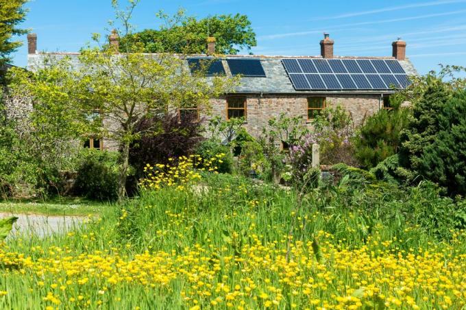 solpaneler og tagvarmeveksler til varmt vand på en tidstypisk ejendom i Cornwall, det sydlige england, Storbritannien