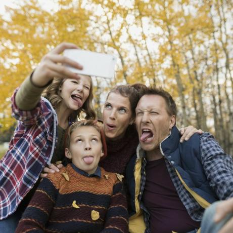 Fjollet familie tager selfie gør ansigter efterårspark