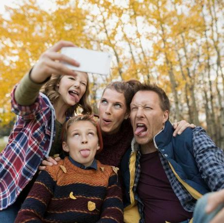 Fjollet familie tager selfie gør ansigter efterårspark