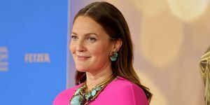 Drew Barrymore iført en lyserød kjole med kappe og turkise smykker til dagtimerne Emmy Award rød løber