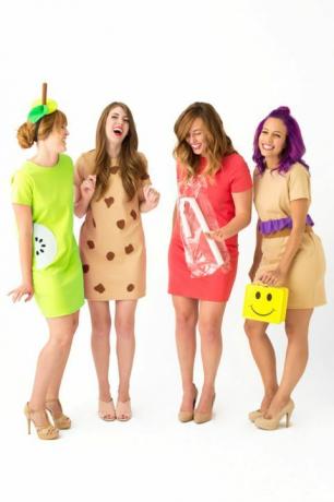fire griner kvinder i korte kjoler klædt ud som "frokost damer", en med en gul smiley ansigt madpakke